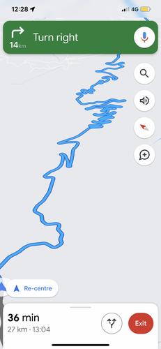 Phone navigation screen showing a winding mountain road