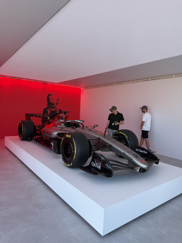 Formula 1 car displayed on a white plinth in a red-lit room